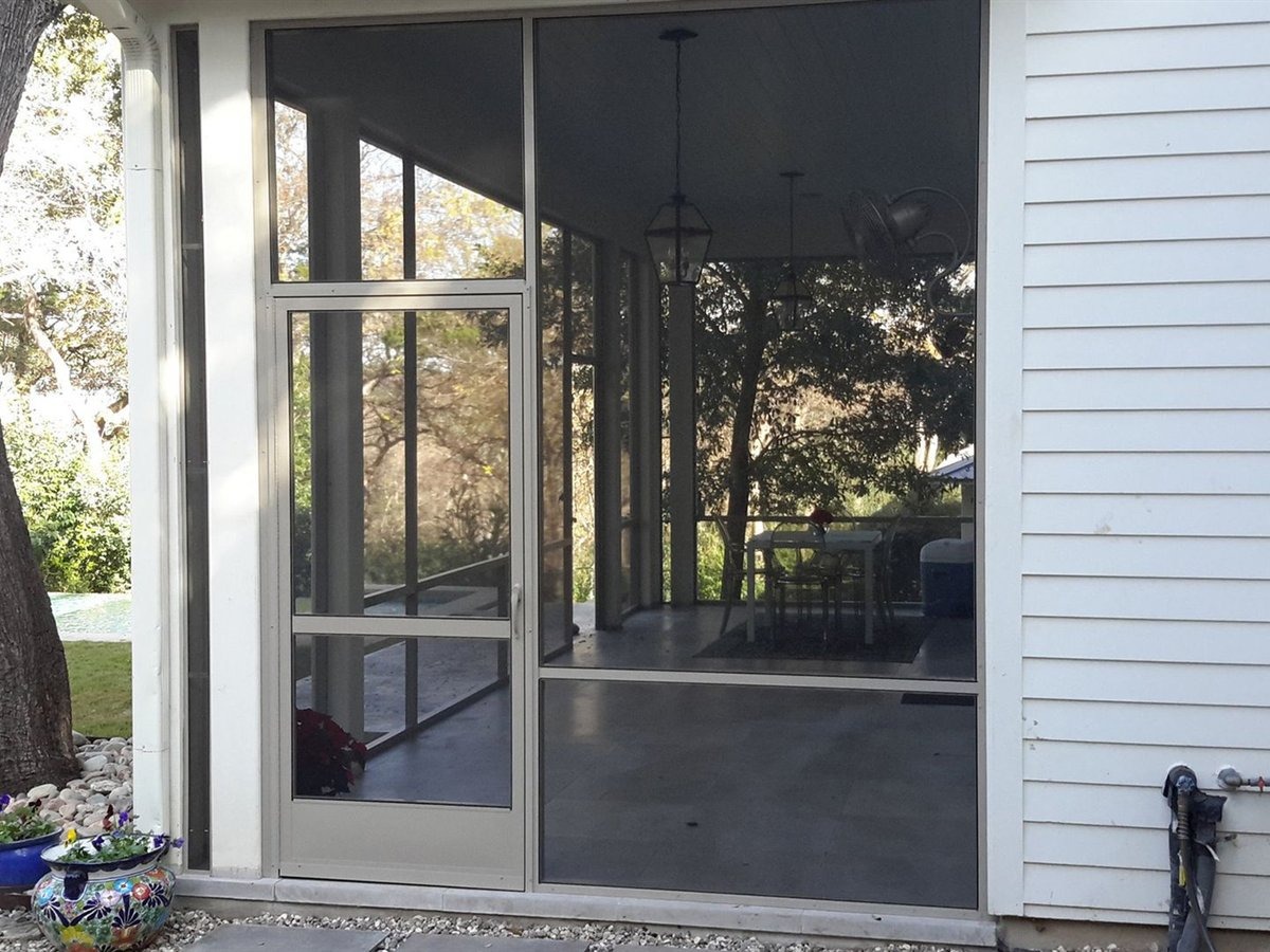 Electrician mounting a wet-rated ceiling fan on an insulated aluminum patio cover