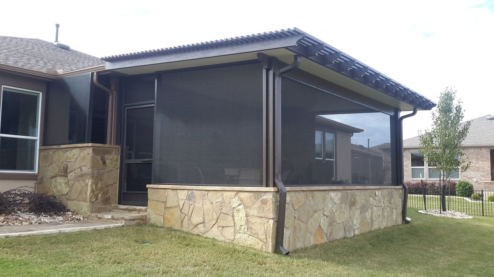 Insulated aluminum patio cover with screens on a two-story home in Plum Creek, Kyle